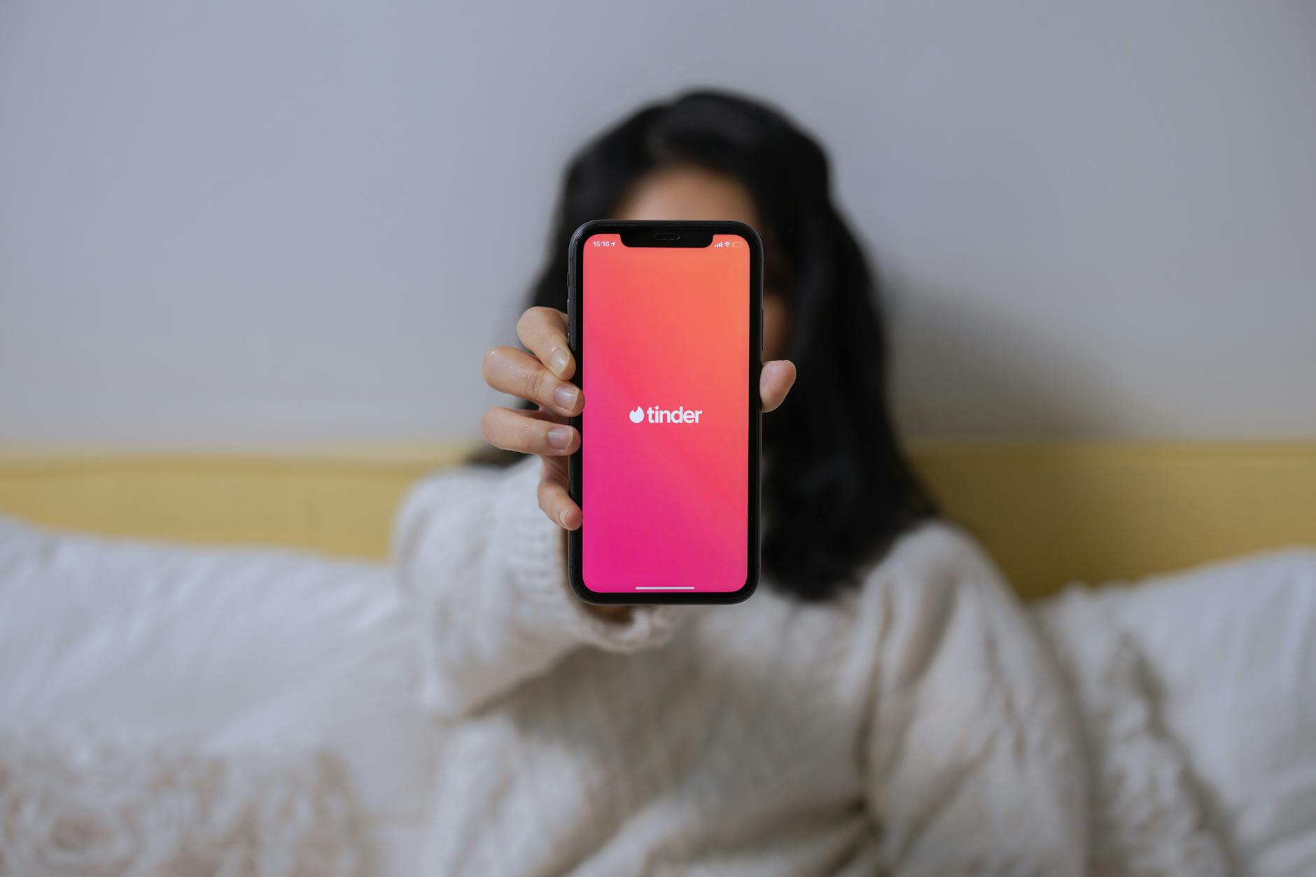 マッチングアプリで業者のプロフィールを見分けるためにスマホ画面を確認する様子