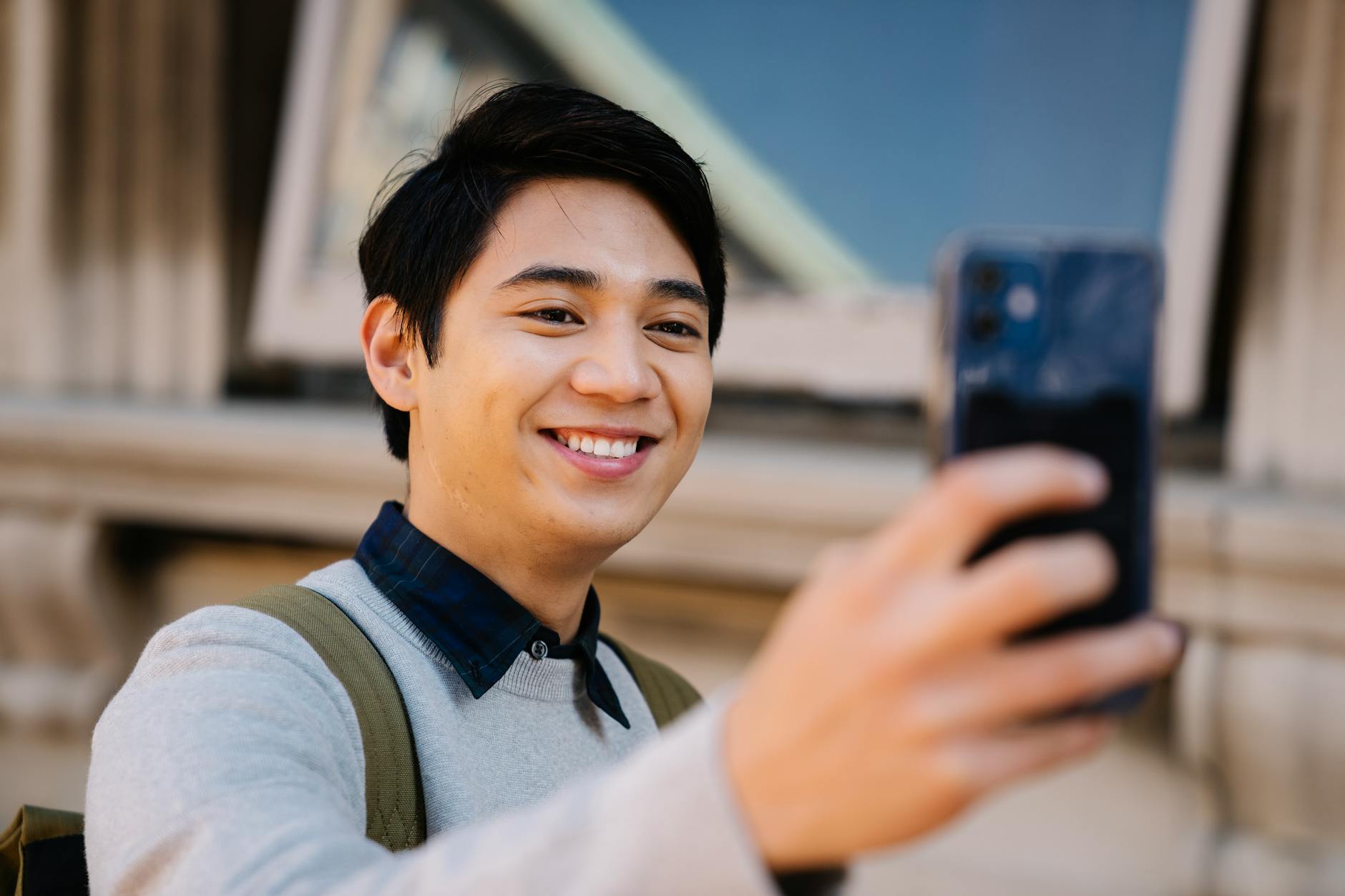 マッチングアプリのプロフィールを攻略するモテ男がスマホを操作する