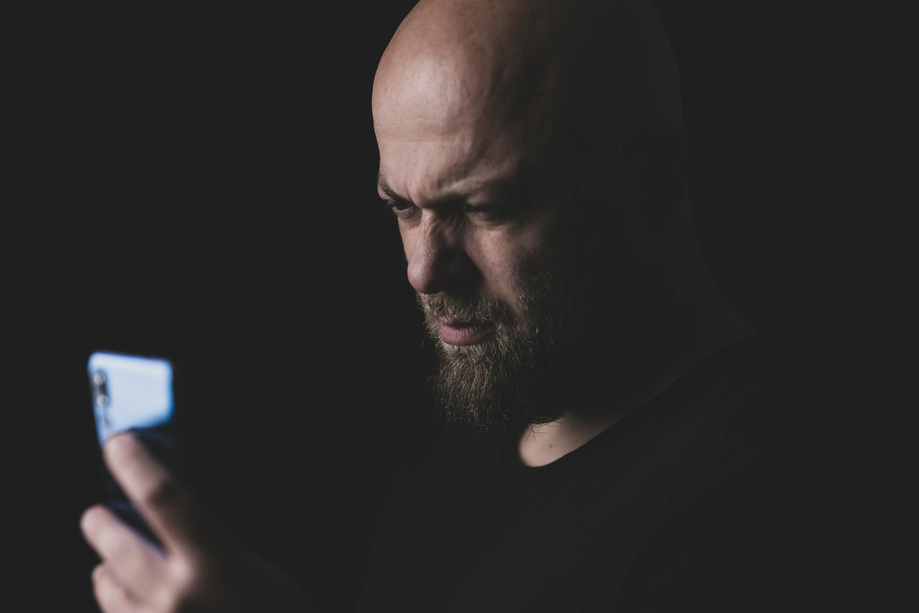マッチングアプリのリスクに注意する30代男性がスマホを真剣に見ている