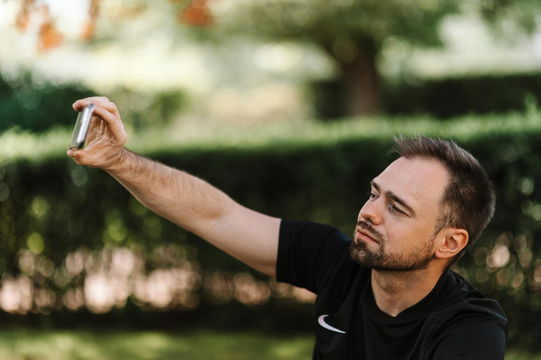マッチングアプリ写真を1人でスマホ三脚を使って撮影する男性